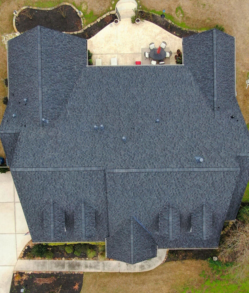 Top-down aerial view of a dark gray architectural shingle roof on a residential home